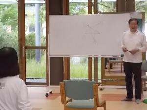 講師が気功についての説明をしている様子です