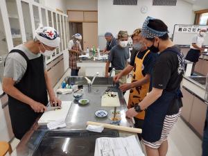 受講生が講師から料理を教わっている様子です