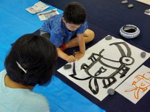 男の子が文字を書いている様子です