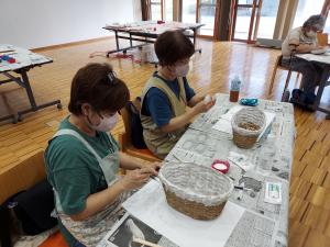 入れ物に和紙を張り付けている受講生の様子です