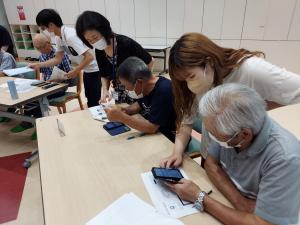学生が受講生にスマホを教えている様子です