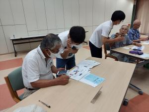 男子学生がスマホを教えている様子です