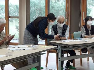 女子学生が個別指導でスマホを教えている様子です
