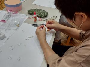 受講生がフェルトに糸で縫い付けている様子です