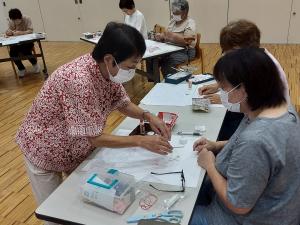 講師がフェルトの縫い方を説明している様子です