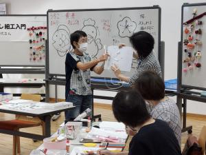 講師がパーツの縫い方を説明している様子です