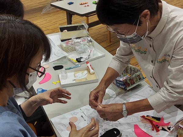 講師がつるし細工のやり方を教えている様子です