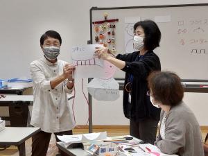 つるし細工の編み方を講師が教えている様子です
