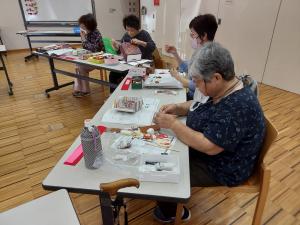 受講生が飾りものを縫っている様子です