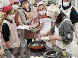 講師がおやきを作るお手本を見せている様子です