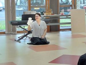 講師が人形を使ってリトミックをしている様子です