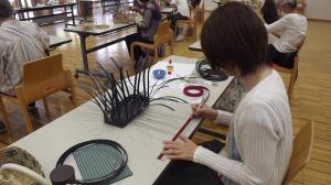 テープの長さを測りながらかごを作っている様子です