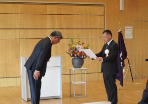 受賞者の松本修さまへ教育長から表彰状を渡す写真