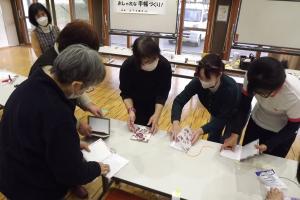 講師の手本を見ながら手帳を作成している様子です