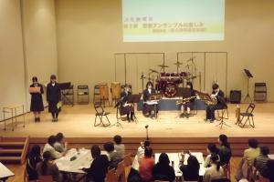 演奏の合間に曲の説明を生徒がしている様子です