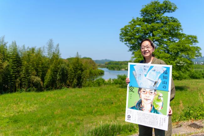 こうのさんが福知山の変のポスターを持っている様子