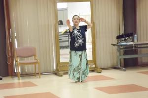 フラダンスのハンドモーションを教えている講師の様子です