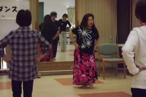 講師がフラダンスのステップを教えている様子です