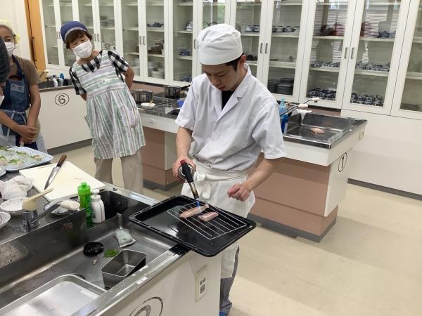 魚をあぶっている講師の様子です