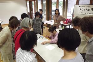 講師が自分が制作をしているのを見せて受講生に教えている様子です