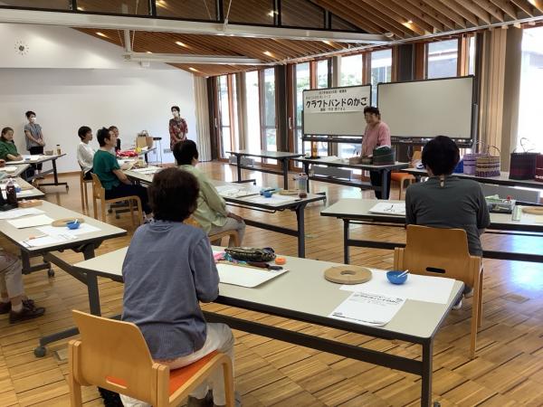 講師が全員にクラフトバンドの扱いについて説明をしている様子です