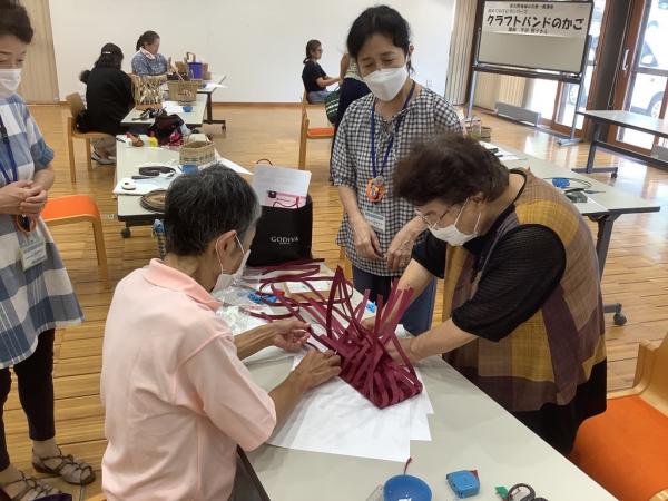 講師が大きなかごの編み方を指導している様子です