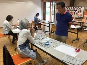 和紙の色の塗り方を講師に聞いている様子です。