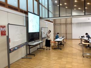 講師がプロジェクターで説明している様子です