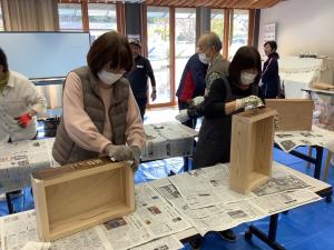 木箱にワックスを塗っている様子です