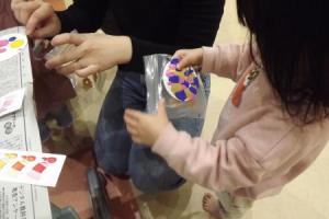 子どもがコースターに色を付けている様子です