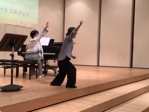 講師が勢いよく手を上げている様子です