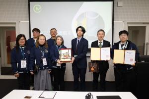 贈りものを受け取る様子。中央福知山市、右隣コアマシナリー岡本社長