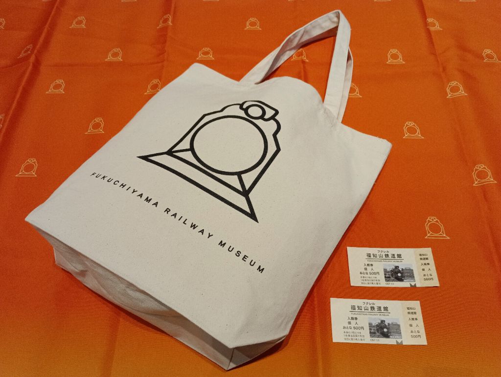 ロゴが印刷されたトートバックと入場券2枚の写真