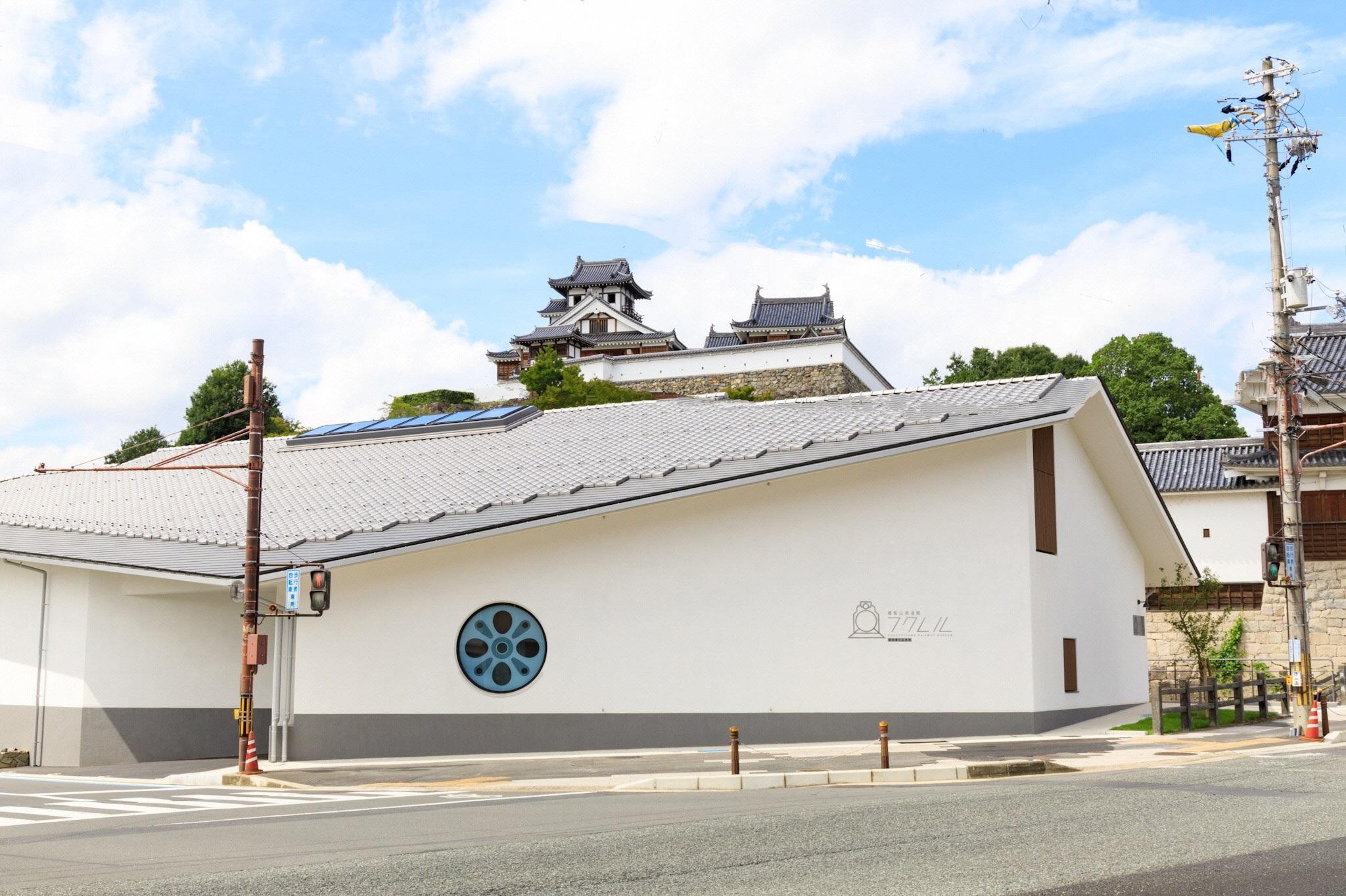 晴天の空の下、お城をバックに福知山鉄道館フクレルがある