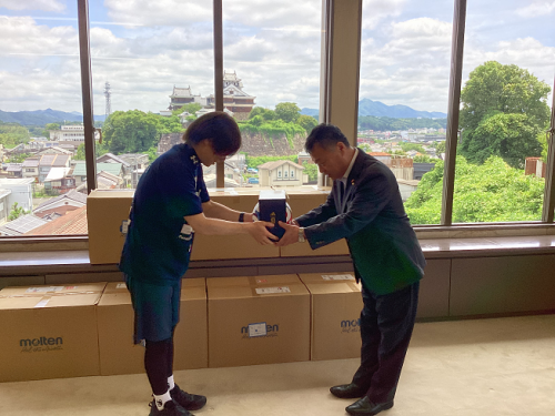 多村PRマネージャーから廣田教育長へサッカーボールを渡す写真
