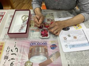 作品に造花を付けている様子です