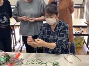 講師が編み方のお手本を教えている様子です