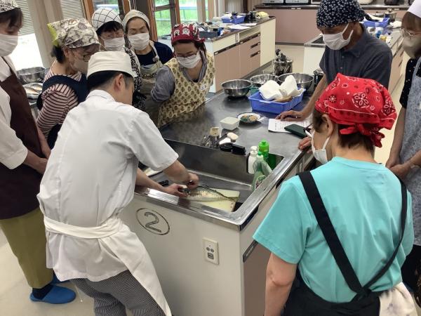 講師が鯵のうろこをとっている様子で