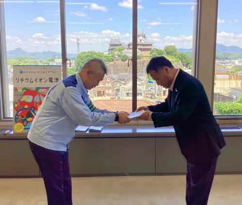 中村社長から廣田教育長へ冊子を手渡す写真