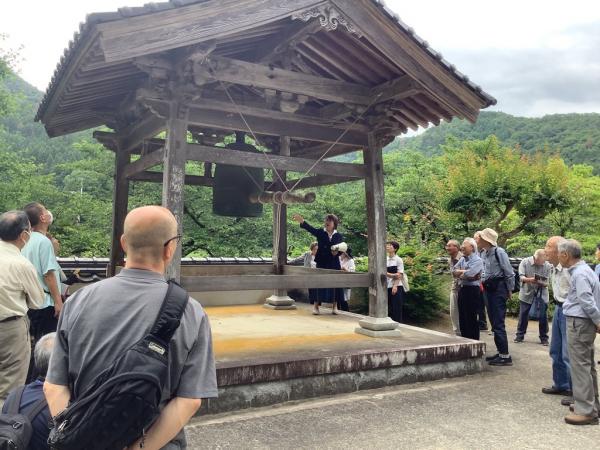 講師が梵鐘の説明をしている様子です