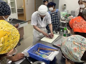 講師が魚をさばいている様子です