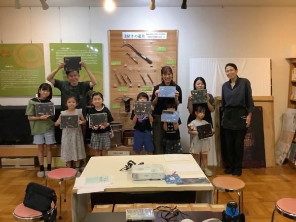 作品を持って記念写真を撮っている様子です