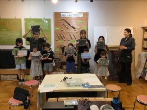 子ども体験教室で作品を持ってみんなで写真を撮っている様子です