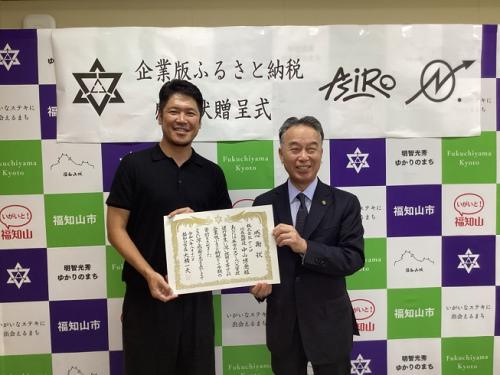 感謝状を持って並ぶ株式会社アシロの中山代表と大橋市長