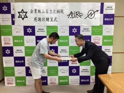 株式会社ナンバーホールディングスの川名代表に感謝状を渡す大橋市長
