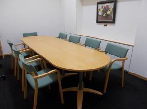 長机と8脚の椅子がある会議室の写真です